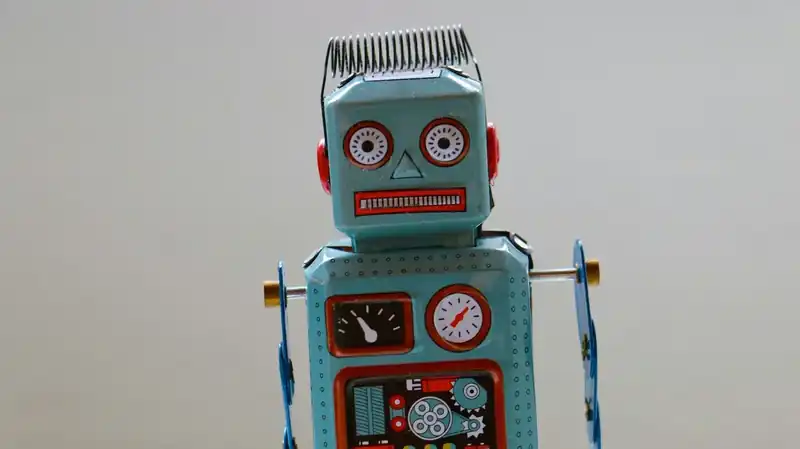 Vintage wind-up tin robot toy with dials and gauges on its chest